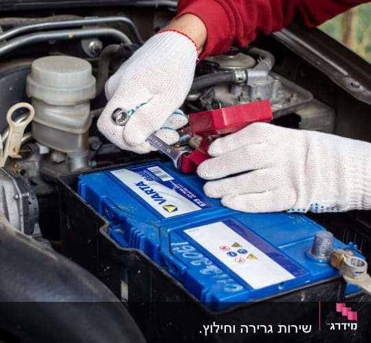 תמונה של תיקון מצבר ברכב עם כפפות לבנות